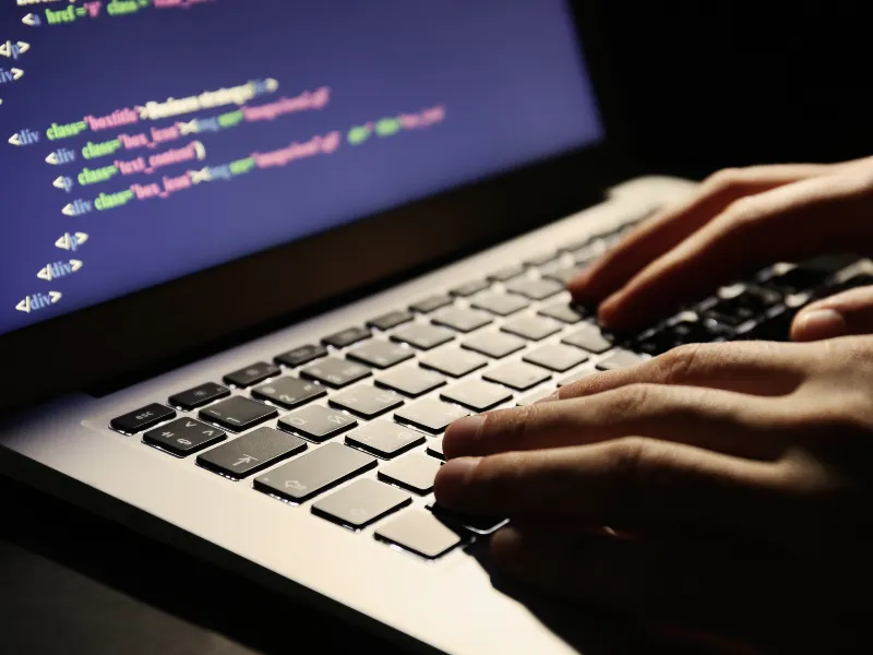 mãos de um homem mexendo no notebook simbolizando crime no ambiente virtual.