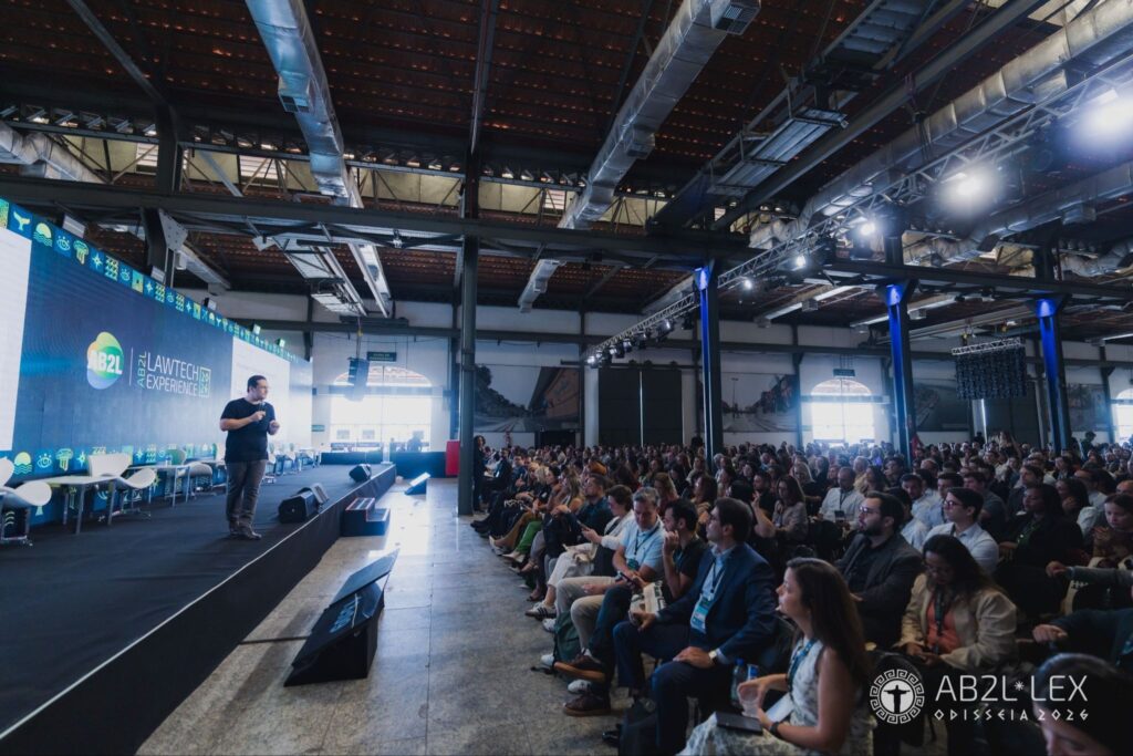 Auditório lotado durante palestra no evento AB2L Lawtech Experience, com palestrante no palco e público sentado acompanhando a apresentação.