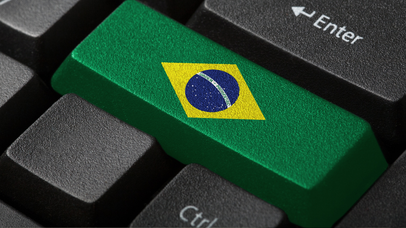 Tecla Enter de teclado com a bandeira do Brasil, simbolizando decisão da Justiça brasileira sobre inteligência artificial