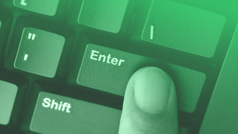 Close de um dedo pressionando a tecla Enter em um teclado de computador com sobreposição de luz verde, simbolizando comandos e automação.